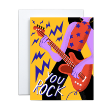 Load image into Gallery viewer, purple abstract person with red tank top and purple stars wearing yellow hoop earrings and black pants playing a red electric guitar with purple lightning bolts coming out with the text 'you rock' on lower left side on a yellow background greeting card