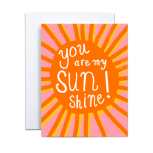 Load image into Gallery viewer, bold orange sun with rays offset by the same image in yellow on a pink background with 'you are my sunshine' written in white in the center greeting card