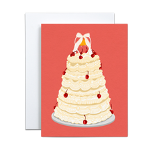 Load image into Gallery viewer, off white wedding cake with several tiers and cherries on a silver platter and a small wedding bell figurine on top with a bow on a salmon pink background greeting card