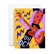 Load image into Gallery viewer, purple abstract person with red tank top and purple stars wearing yellow hoop earrings and black pants playing a red electric guitar with purple lightning bolts coming out with the text &#39;you rock&#39; on lower left side on a yellow background greeting card
