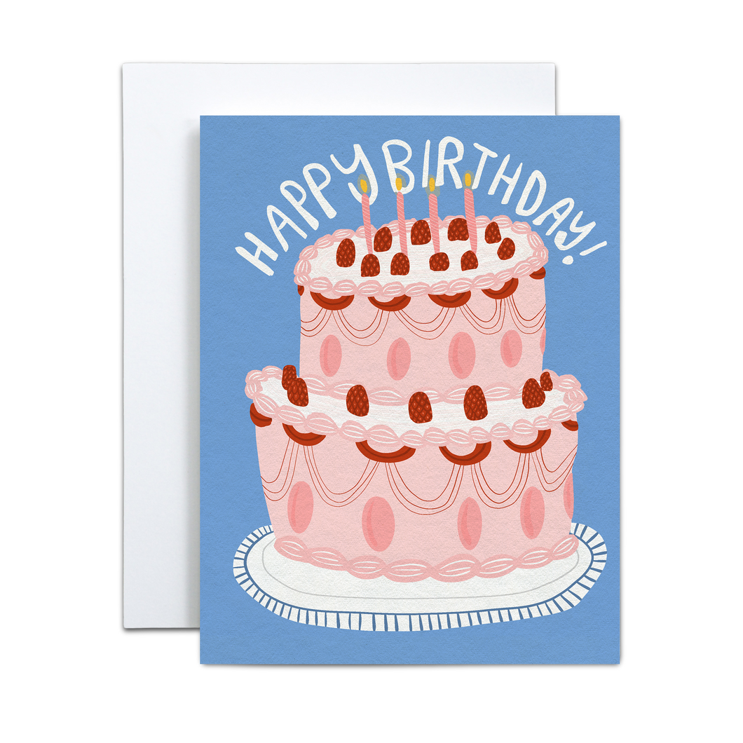pink cake with pink and red icing details with red raspberries and pink candles on top on abstract white platter and blue background with the phrase 'happy birthday' in hand written font on top birthday card