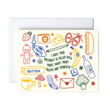 Load image into Gallery viewer, A birthday greeting card with a cream background and colorful doodle illustrations, shown with a white envelope behind it. The card features playful text and icons including a hot dog, banana, bottle, mushroom, and stars.
