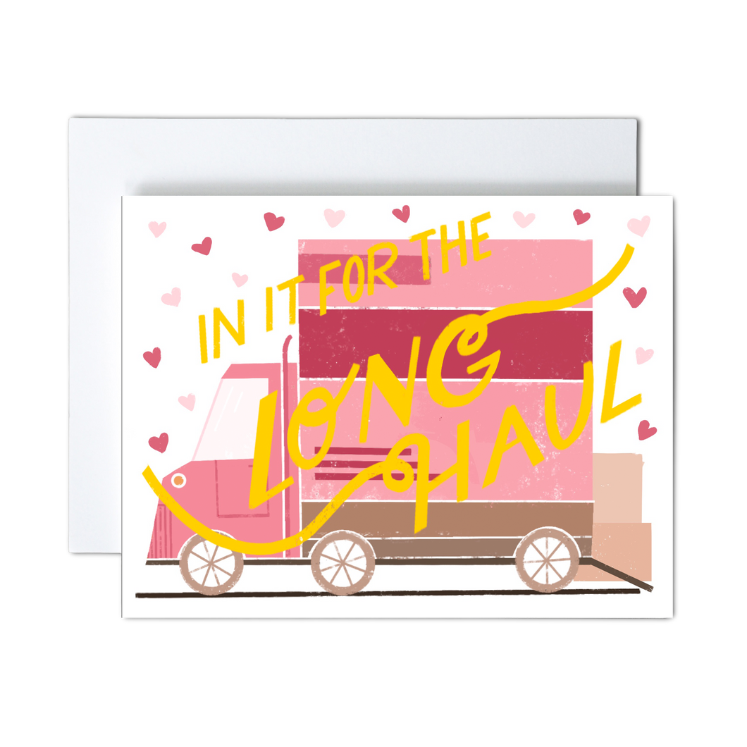 pink, dark pink, and shades of brown moving van with boxes ready to load and pink hearts with yellow 'in it for the long haul' script text over the front greeting card